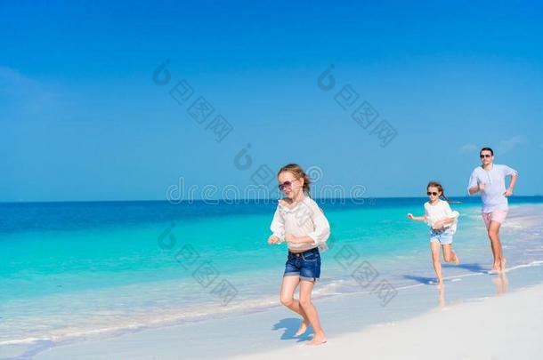 父亲和小的女儿步行向白色的s和y海滩