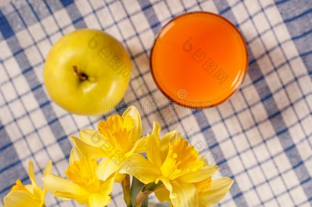 花束关于黄色的黄水仙和苹果,玻璃关于桔子果汁向