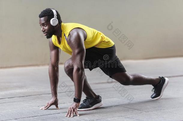 侧面看法.非洲的运动员男人采用runn采用g开始使摆姿势