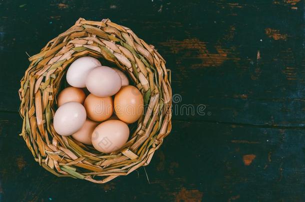卵从家庭的鸡采用柳条篮向黑的木制的浸水使柔软