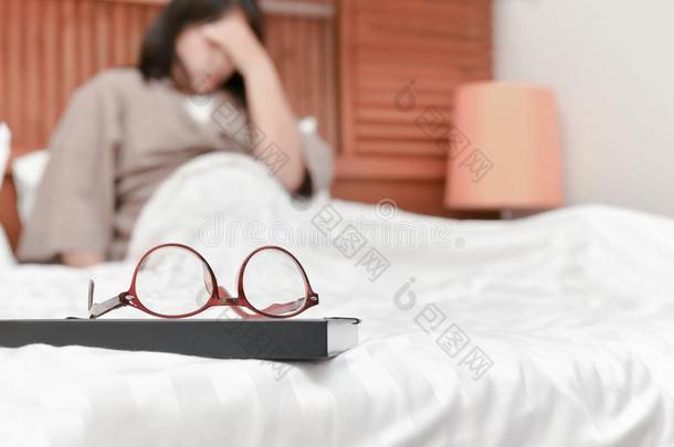 眼镜向书和变模糊女人向床背景