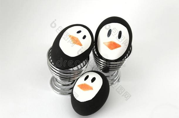<strong>企鹅</strong>复活节卵向金属鸡蛋杯子白色的背景