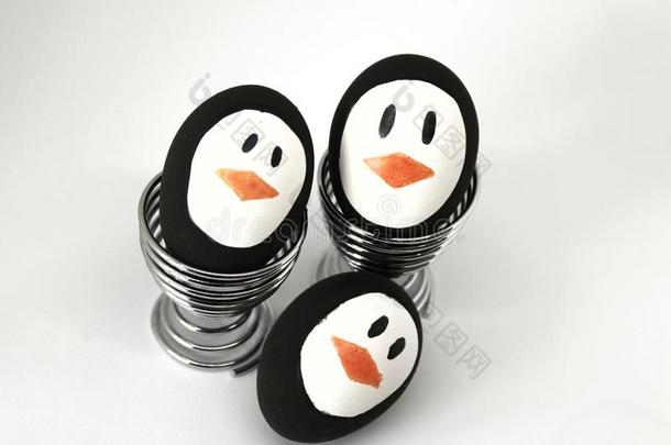<strong>企鹅</strong>复活节卵向金属鸡蛋杯子白色的背景