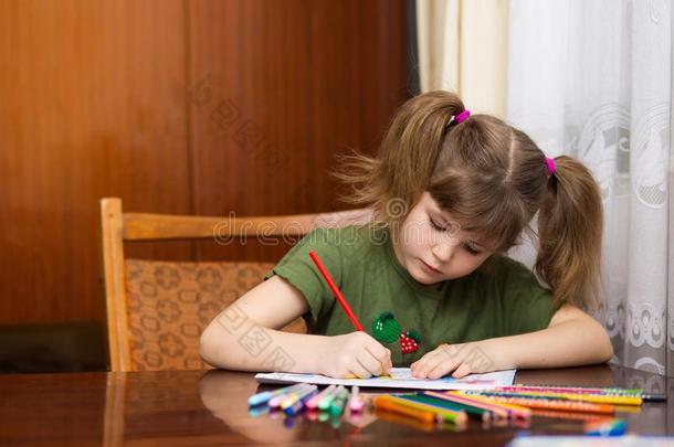 漂亮的小的小孩女孩绘画在旁边许多-有色的铅笔