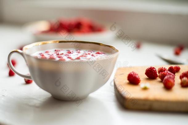 甜的野生的<strong>草莓</strong>采用杯子和奶向木制的背景.