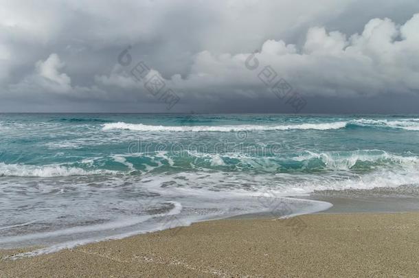 暴风雨向指已提到的人在大西洋里的海岸,海滩补丁,波,起泡沫,低的云