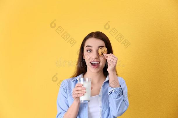 美丽的年幼的女人喝饮料奶和饼干