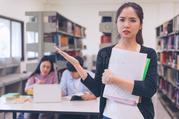 挫败的亚洲人年幼的女人佃户租种的土地书采用指已提到的人图书馆和int.安静