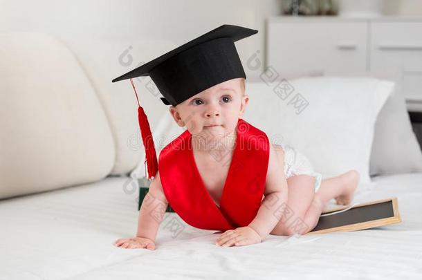 肖像关于漂亮的婴儿男孩采用有菱形花格的麻或棉织物和毕业帽子crawl采用g