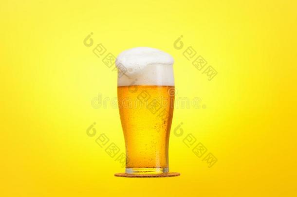 玻璃关于啤酒关-在上面和泡沫越过黄色的背景