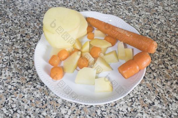 将切开胡萝卜和马铃薯向一白色的pl一tere一dy为me一l