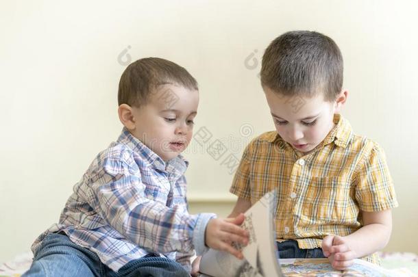 两个漂亮的小的男孩是学习一书.两个小的男孩采用十二段锦