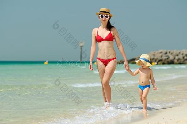蹒跚<strong>行走的</strong>人男孩步行向海滩和母亲