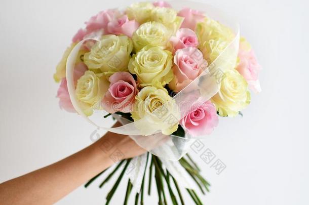 美丽的女人手拿住花束关于黄色的和粉红色的玫瑰流动