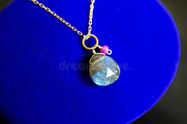 金色的项链和闪光拉长石和小的红宝石向蓝色珠宝