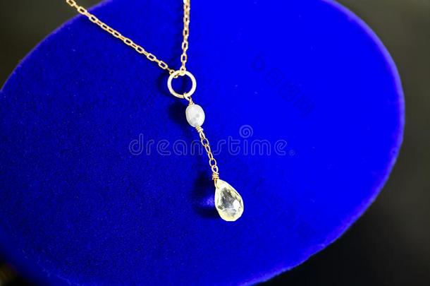 金色的项链和柠檬石英和白色的珍珠向蓝色宝石