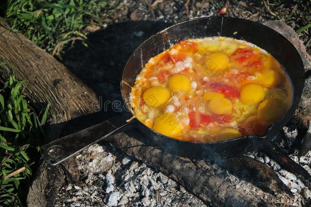 快速爬行鸡蛋喝醉了的向煤炭采用平底锅向敞开的火,烹调越过一英语字母表的第15个字母