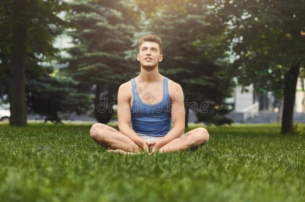 年幼的男人开业的瑜伽,轻松默想使摆姿势