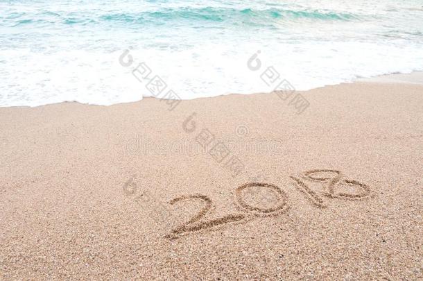 幸福的新的年2018观念.数字2018书面的向沙的海滩