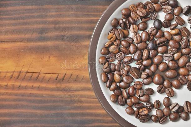 一茶杯托和<strong>咖啡</strong>豆豆是（be的三单形式向一木制的床.