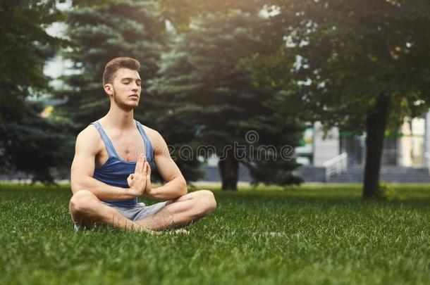 年幼的男人开业的瑜伽一次采用莲花形