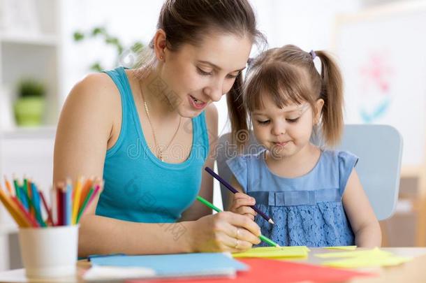 <strong>幼儿园教师</strong>和小孩女孩绘画功课在学校