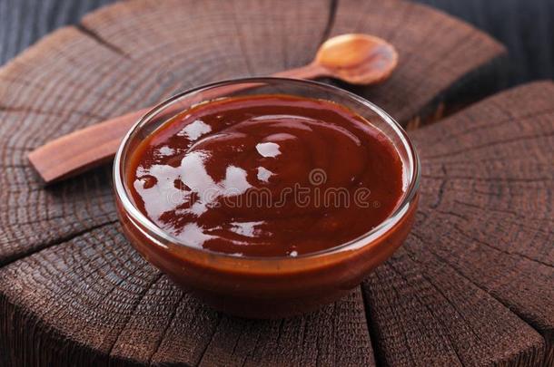番茄酱采用碗向黑暗的木制的背景