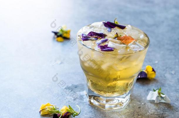 药草的冰冷的茶水鸡尾酒和可以吃的花和压碎的冰.