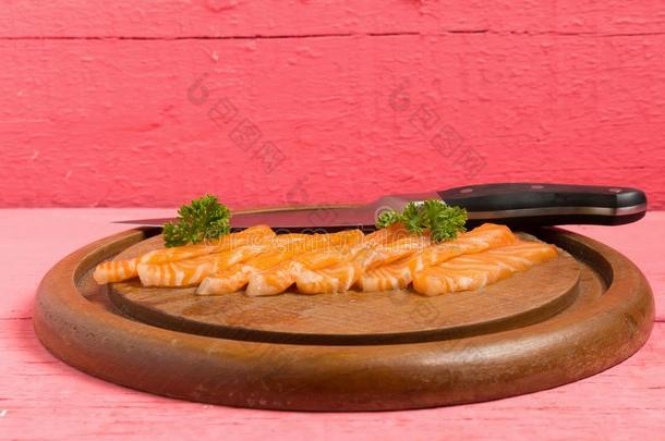 鲑鱼寿司向锋利的板和花向木材颜色粉红色的