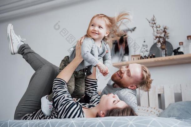 幸福的家庭母亲,父亲和小孩女儿笑声采用床