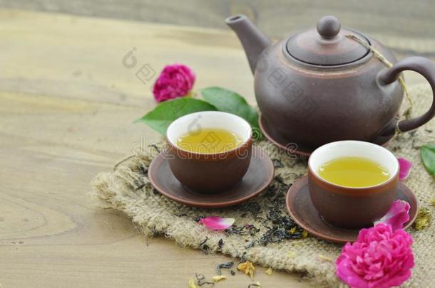 <strong>茶杯和茶壶和</strong>新鲜的花向木制的背景