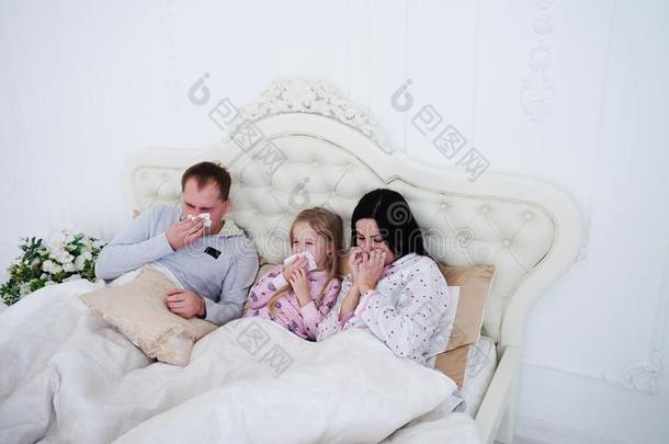 父亲,母亲和小的女儿打喷嚏和餐巾,戴林