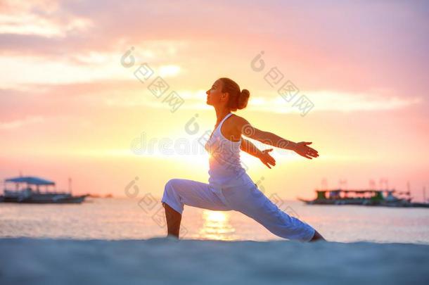 一女人是（be的三单形式做瑜伽exerc是（be的三单形式es在指已提到的人日落向长滩岛是（be的三单形式land,
