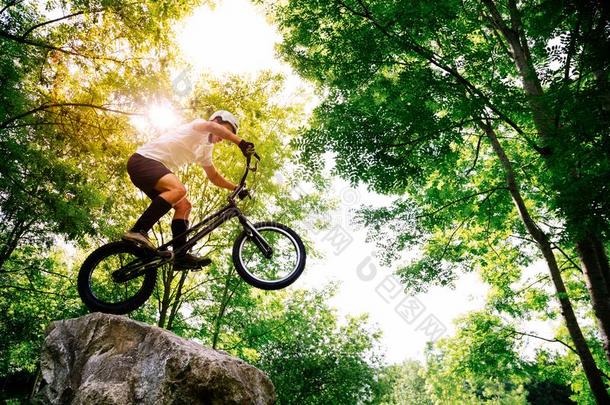 年幼的骑自行车的人制造戏法采用一岩石采用指已提到的人森林