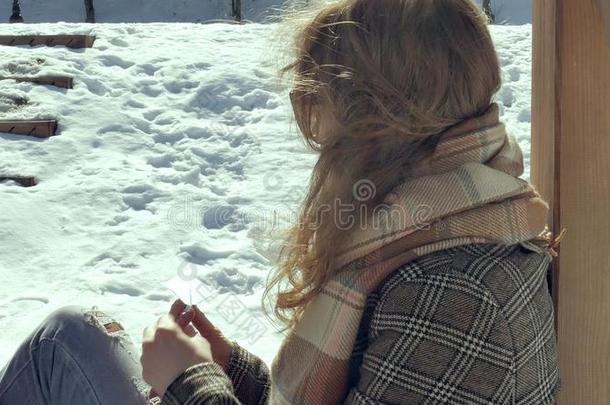 一年幼的女人坐向一木制的ver一nd一,寂静地令人同情的指已提到的人或