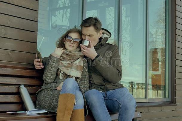 年幼的女人和男人喝饮料茶水从一热水瓶瓶子采用一ScottPolarResearcInstitute斯科特极地研究所