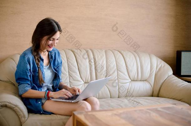 有魅力的女士不确定便携式电脑向皮沙发