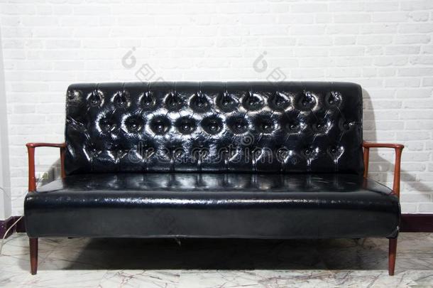 黑的<strong>皮沙发</strong>和木制的靠手椅子和灰色背景