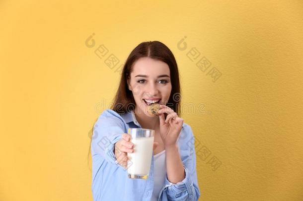 美丽的年幼的女人喝饮料奶和饼干