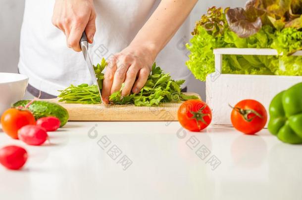 女人烹饪术健康的食物,将切开绿色的蔬菜沙拉.健康的英语字母表的第12个字母