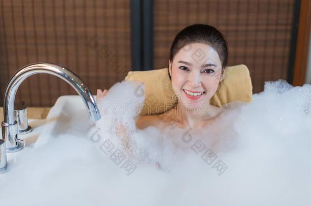 女人拿泡沐浴和演奏采用沐浴tub