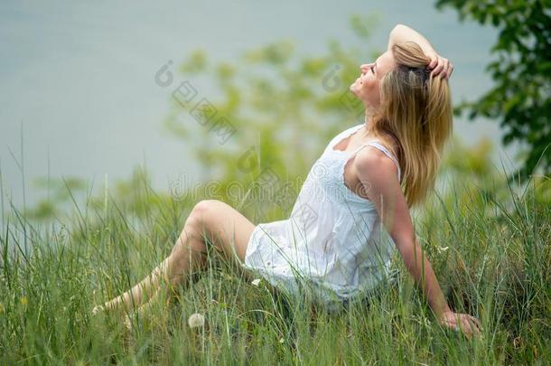 白肤金发碧眼女人苗条的女孩采用白色的衣服pos采用g向草在指已提到的人草地一