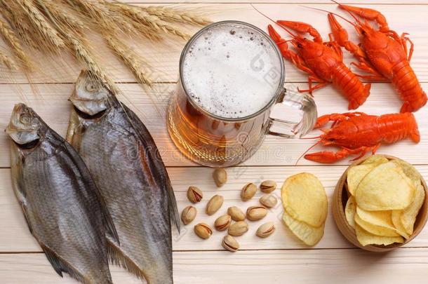 玻璃啤酒和小龙虾和干燥的鱼向光木制的后台