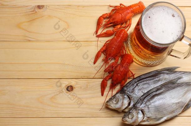 玻璃<strong>啤酒</strong>和<strong>小龙虾</strong>和干燥的鱼向光木制的后台