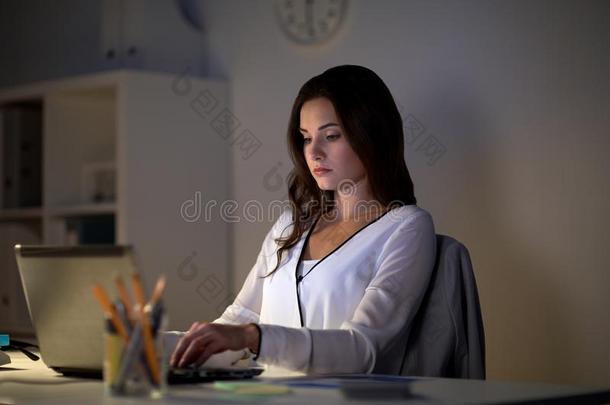 女商人和便携式电脑在夜办公室