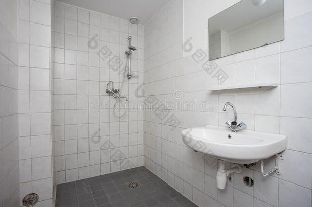 简单的,老的干净的浴室和白色的平铺的地面淹没和秀