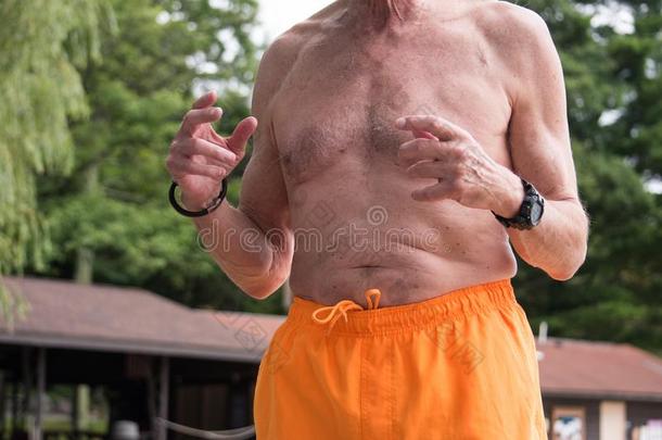 躯干看法关于年长的男人光秃秃的有胸腔的采用黄色的bath采用g一套外衣穿着