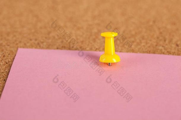 粉红色的纸憔悴和黄色的食物向棕色的软木板背景