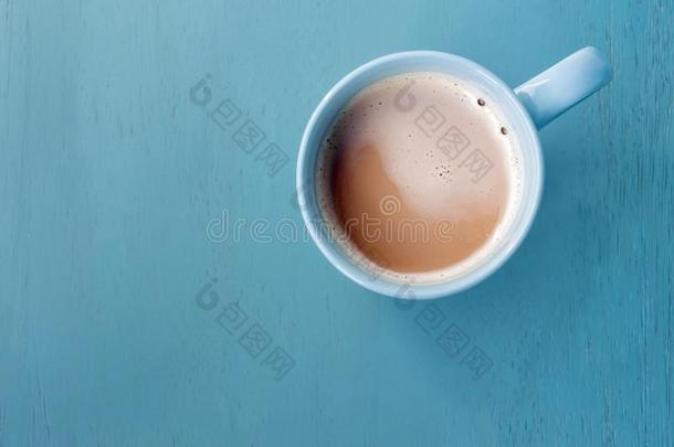 奶咖啡豆采用蓝色杯子向彩色粉笔蓝色木制的地面