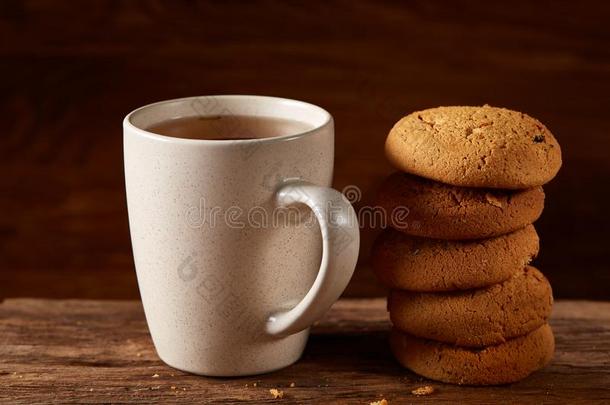 白色的瓷马克杯关于茶水和甜的甜<strong>饼干</strong>向块关于木材oval卵形的